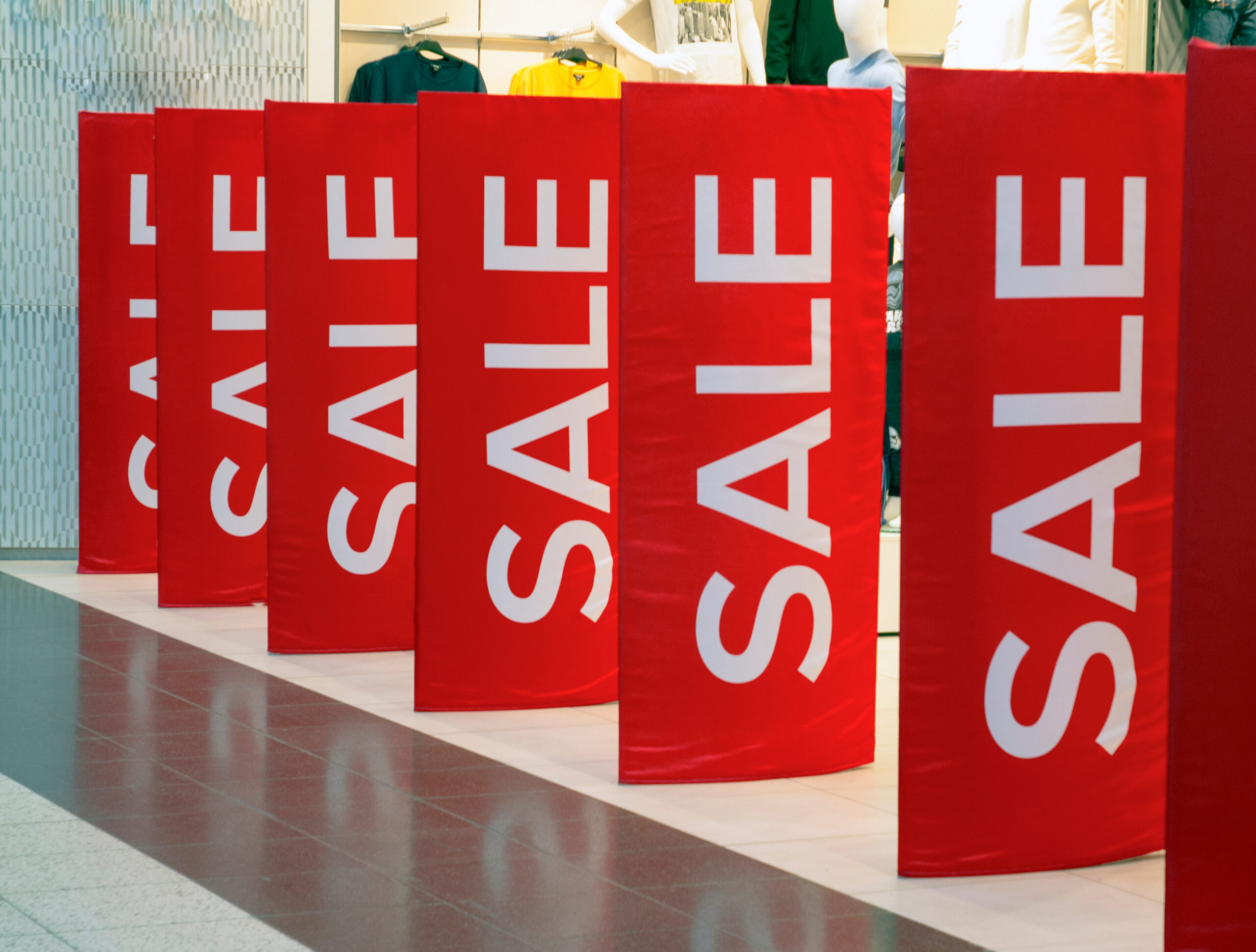 A storefront with sale signs for the holidays
